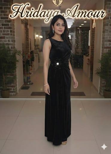 Model in a black one-shoulder draped gown with jeweled waist detail